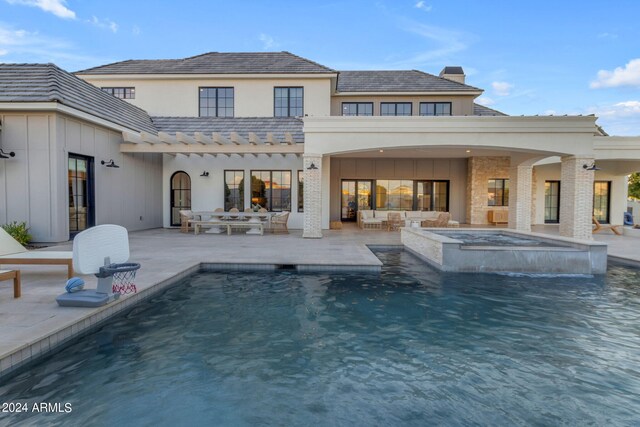 view of pool with an in ground hot tub, pool water feature, and a patio area