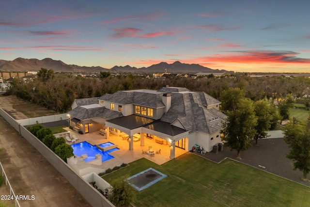 exterior space featuring a fenced backyard, a mountain view, a lawn, stucco siding, and a patio area