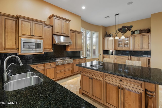 kitchen featuring decorative backsplash, sink, stainless steel appliances, and dark stone counters