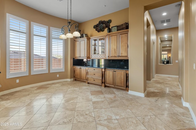 kitchen featuring hanging light fixtures, tasteful backsplash, and an inviting chandelier