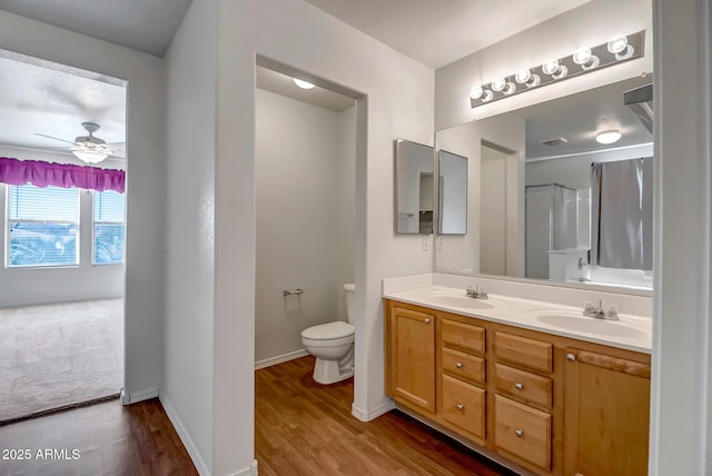 bathroom with vanity, hardwood / wood-style floors, toilet, and ceiling fan