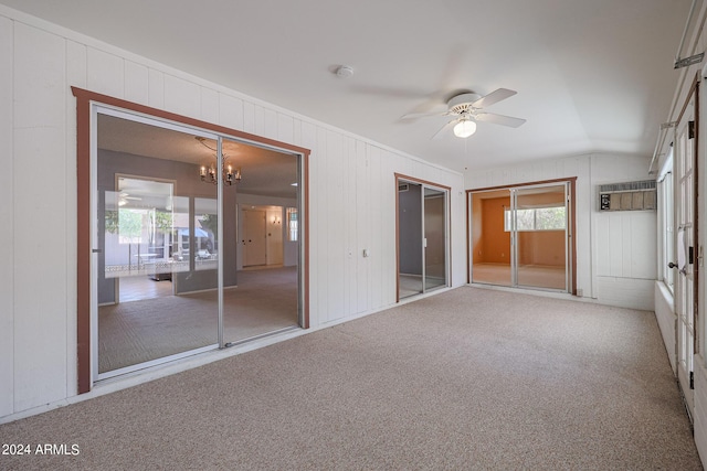 unfurnished bedroom featuring multiple closets, carpet, and ceiling fan with notable chandelier