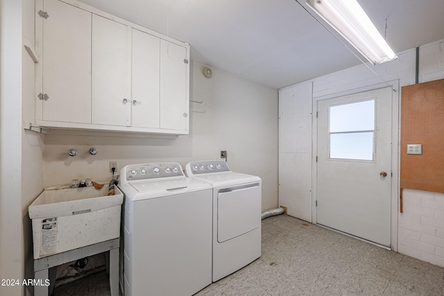 laundry area with cabinets, washer and clothes dryer, and sink