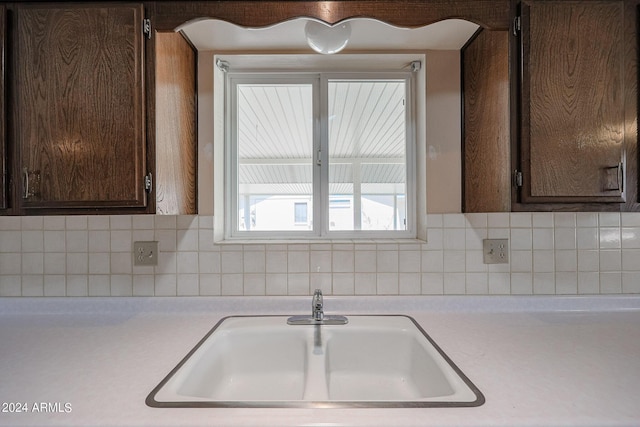 kitchen with decorative backsplash, sink, and dark brown cabinets