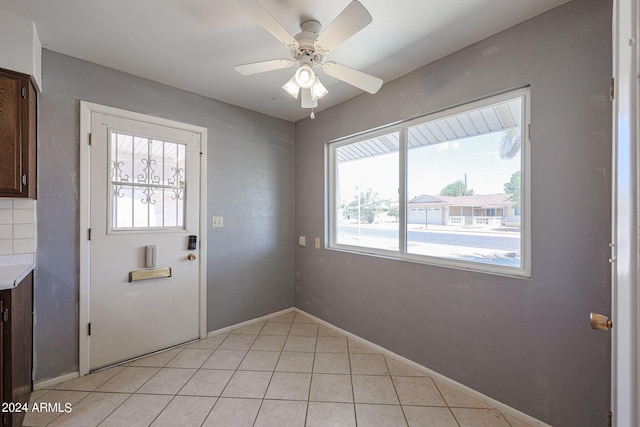 entryway with ceiling fan and light tile patterned flooring