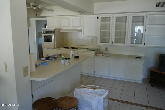 kitchen featuring ceiling fan, white electric cooktop, light tile patterned floors, and white cabinets