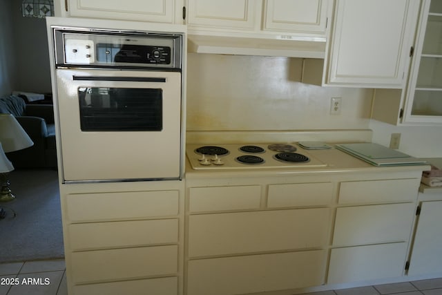 kitchen with white cabinetry, light tile patterned floors, and white appliances