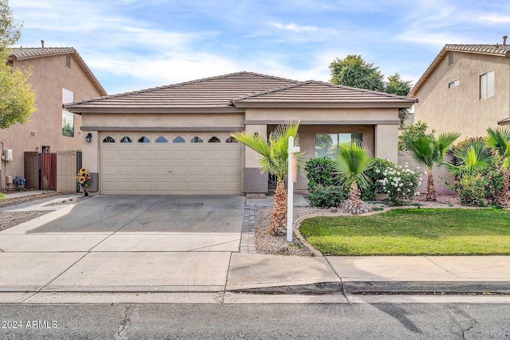 view of front of home featuring a garage and a front lawn