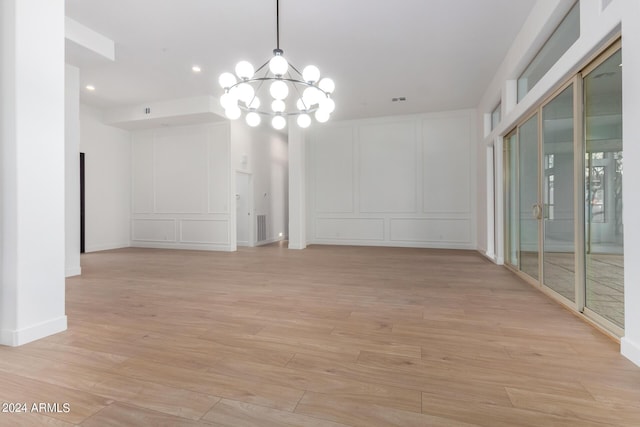 interior space featuring light wood finished floors, visible vents, a decorative wall, a chandelier, and recessed lighting