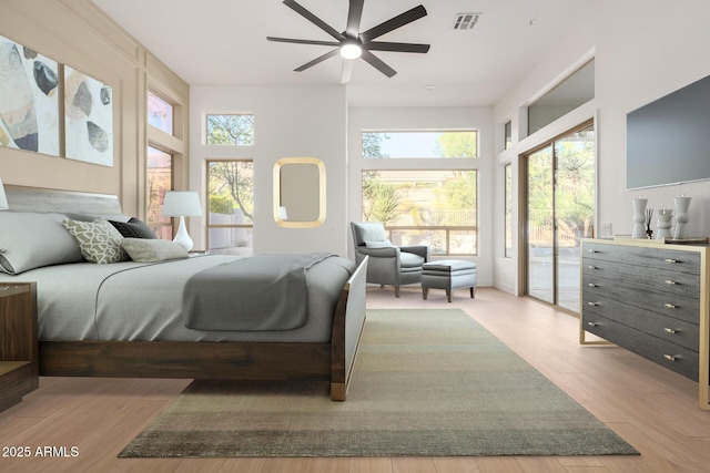 bedroom featuring ceiling fan, wood finished floors, visible vents, and access to exterior
