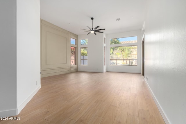 unfurnished room with light wood-style floors, baseboards, and ceiling fan