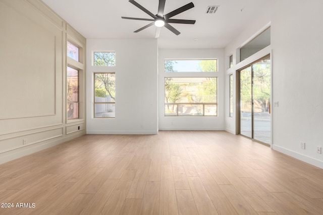 interior space featuring light wood-type flooring, baseboards, a ceiling fan, and visible vents