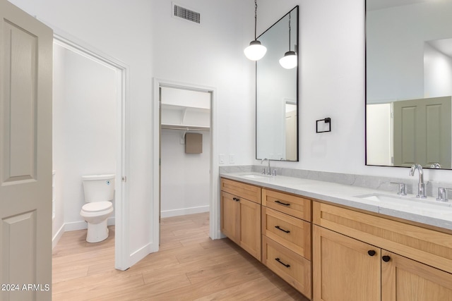 bathroom featuring a sink, toilet, visible vents, and wood finished floors