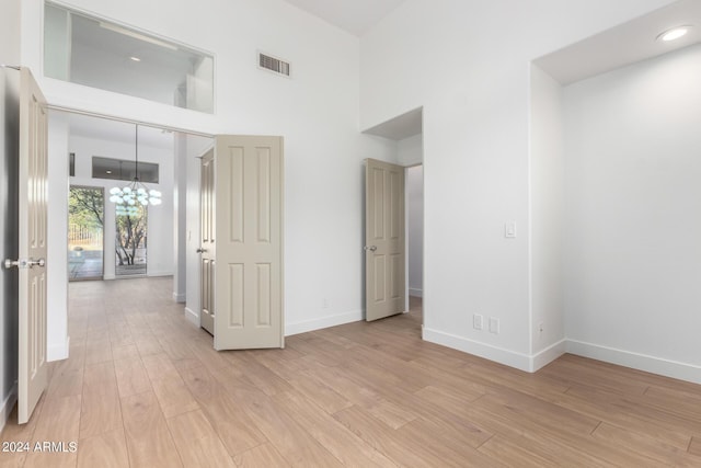 spare room with a towering ceiling, baseboards, and visible vents