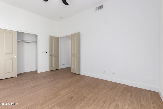 unfurnished bedroom featuring baseboards, a closet, light wood-style flooring, and visible vents