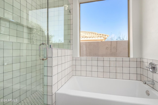 bathroom featuring a garden tub and a shower stall