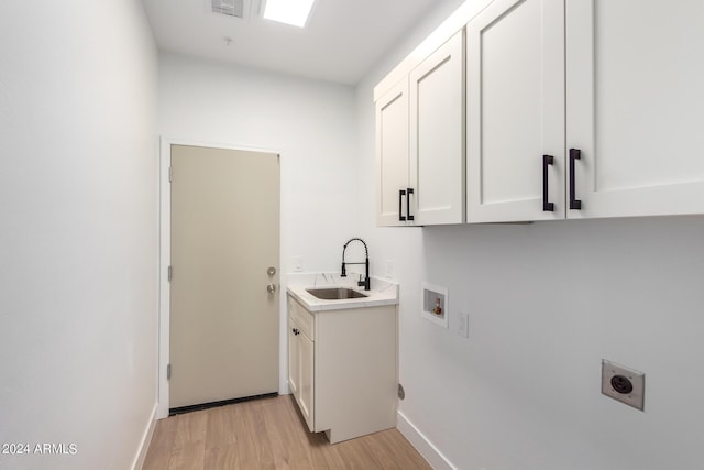 laundry area with light wood-style flooring, hookup for a washing machine, a sink, cabinet space, and electric dryer hookup