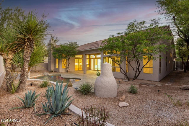 back of house with fence, an outdoor pool, a patio, stucco siding, and a tiled roof