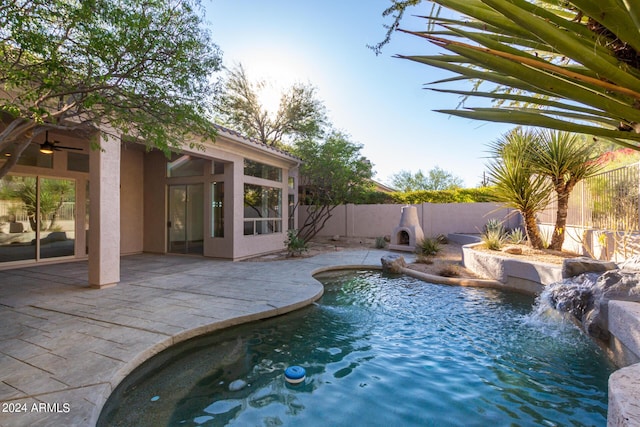 view of swimming pool featuring a patio, a sunroom, ceiling fan, a fenced backyard, and a fenced in pool