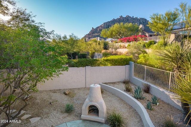 view of home's community with a mountain view and fence private yard