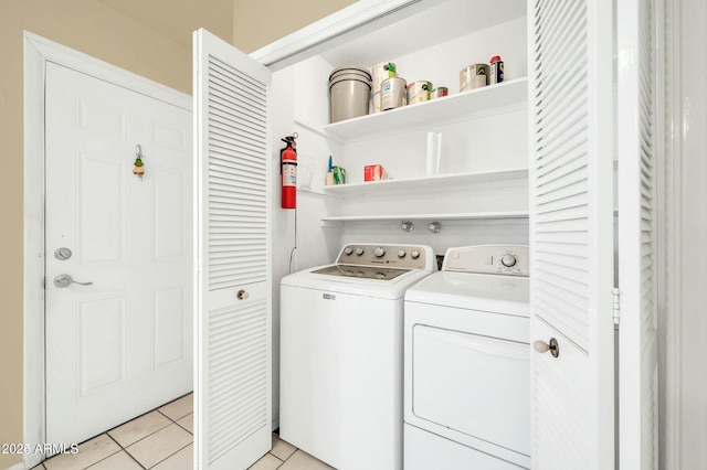 laundry room with independent washer and dryer and light tile patterned floors