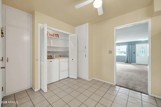 clothes washing area with washer and clothes dryer, light colored carpet, and ceiling fan