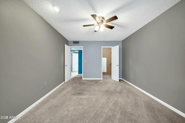 unfurnished bedroom with ceiling fan, light carpet, and a textured ceiling