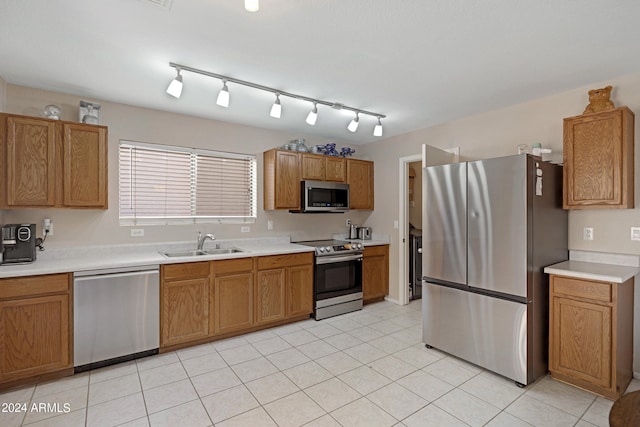 kitchen with light tile patterned floors, stainless steel appliances, and sink