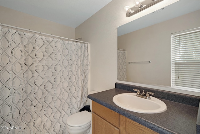 bathroom with vanity, toilet, and curtained shower