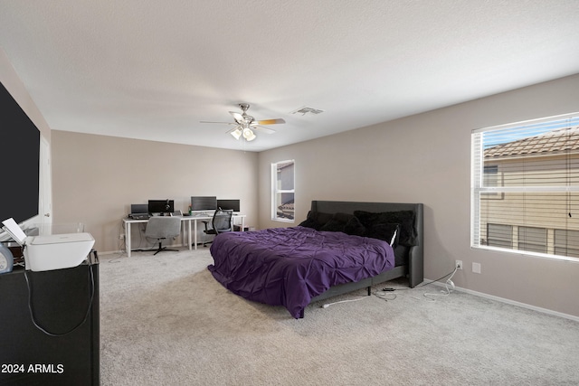 carpeted bedroom featuring a textured ceiling and ceiling fan