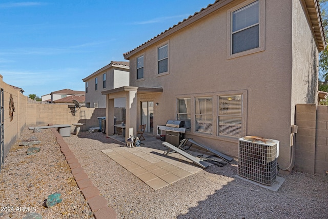 back of property with central AC unit and a patio area