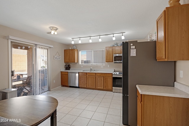 kitchen featuring plenty of natural light, sink, appliances with stainless steel finishes, and light tile patterned flooring