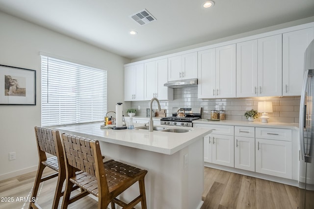 644 N Vine St, Chandler, AZ 85225 - kitchen featuring a sink, backsplash, under cabinet range hood, a breakfast bar area, and recessed lighting