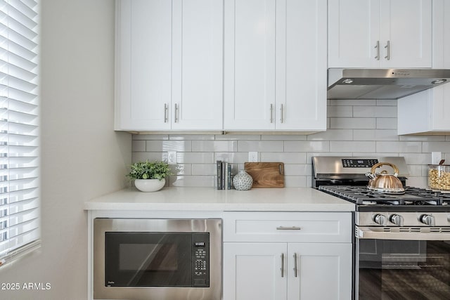 644 N Vine St, Chandler, AZ 85225 - kitchen with stainless steel gas stove, built in microwave, under cabinet range hood, white cabinets, and tasteful backsplash