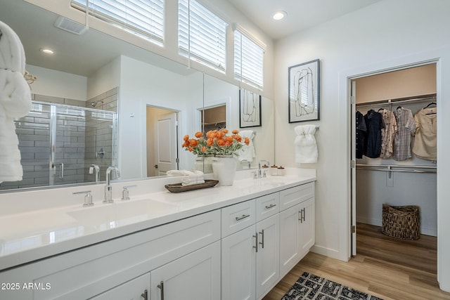 644 N Vine St, Chandler, AZ 85225 - bathroom featuring double vanity, a shower stall, a walk in closet, wood finished floors, and recessed lighting