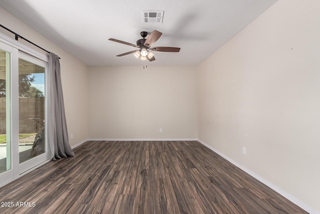 unfurnished room featuring dark wood-style floors, visible vents, baseboards, and ceiling fan