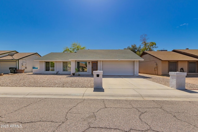 ranch-style home featuring a shingled roof, an attached garage, driveway, and stucco siding