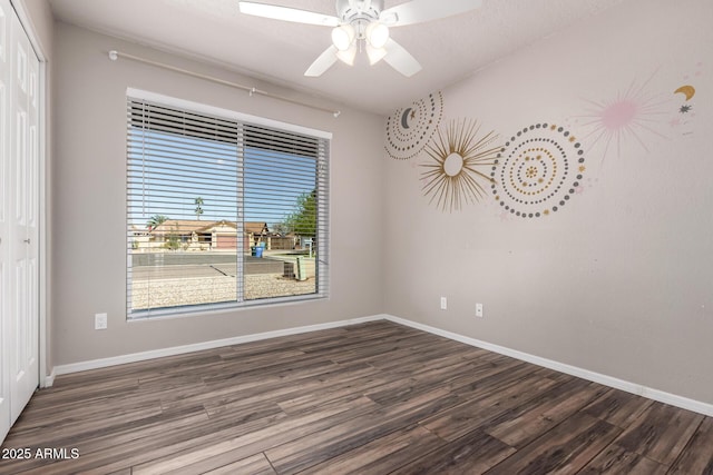 empty room with baseboards, wood finished floors, and a ceiling fan