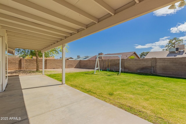 view of yard featuring a patio, a fenced backyard, and a playground