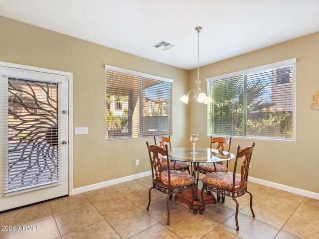 tiled dining space with a chandelier