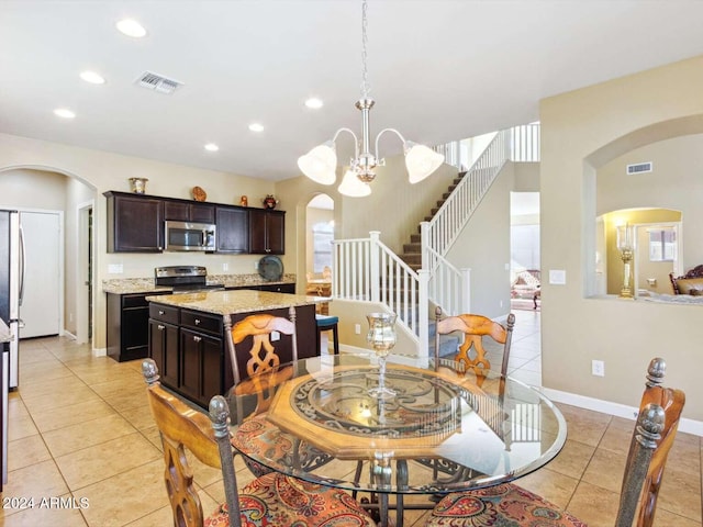 tiled dining room with an inviting chandelier