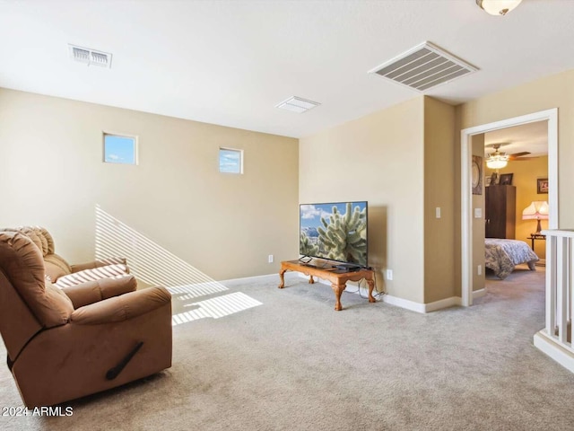 carpeted living room with ceiling fan