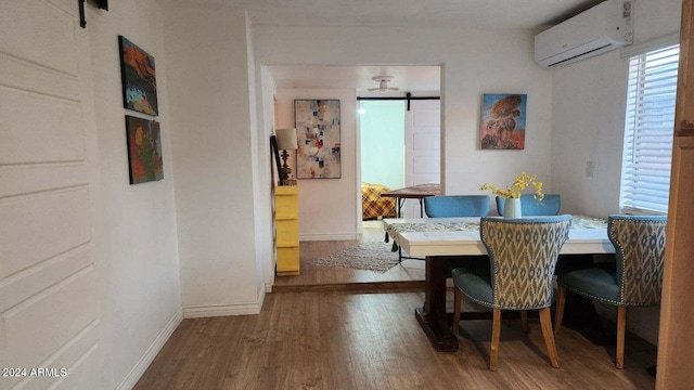 110 N Pinal Ave, Superior, AZ 85173 - dining space featuring a wall unit AC, a barn door, and wood-type flooring