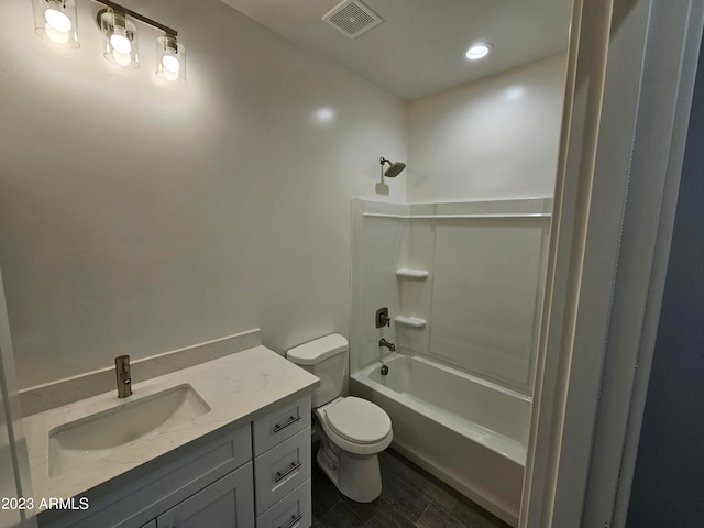 full bathroom with hardwood / wood-style flooring, washtub / shower combination, toilet, and vanity