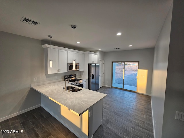 kitchen featuring white cabinets, dark hardwood / wood-style floors, stainless steel appliances, and kitchen peninsula