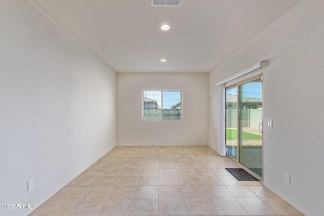 spare room with light tile patterned floors and a wealth of natural light