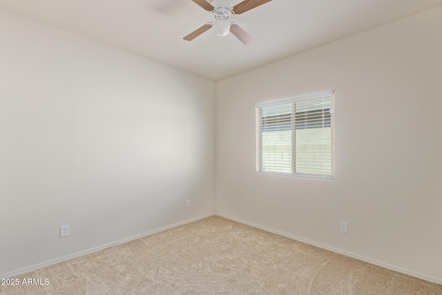 spare room with light colored carpet and ceiling fan