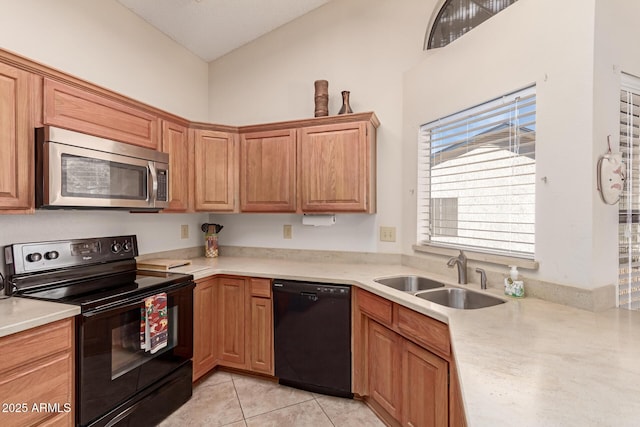 kitchen featuring light tile patterned floors, sink, and black appliances