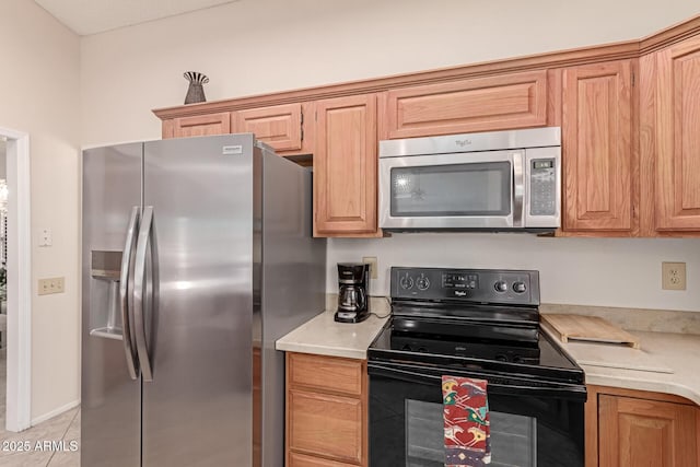 kitchen featuring stainless steel appliances and light tile patterned flooring