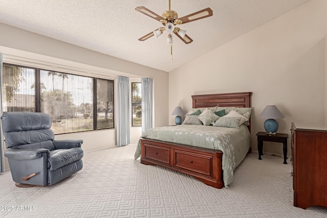 carpeted bedroom with ceiling fan, lofted ceiling, and a textured ceiling